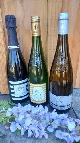 trois bouteilles de vin posées à côté de fleurs violettes dans l'établissement La Demoiselle, à Les Ponts-de-Cé