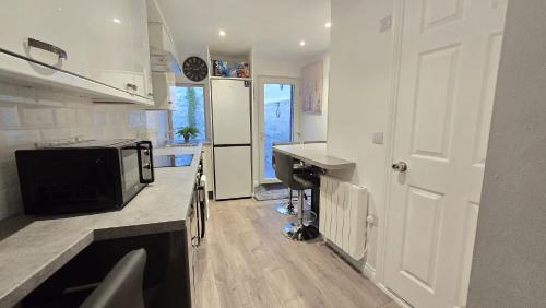 a kitchen with a refrigerator and a sink and a microwave at Central & Stylish, Two Bed, Two Bath in Galway