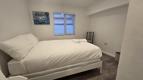 a white bed in a room with a window at Central & Stylish, Two Bed, Two Bath in Galway