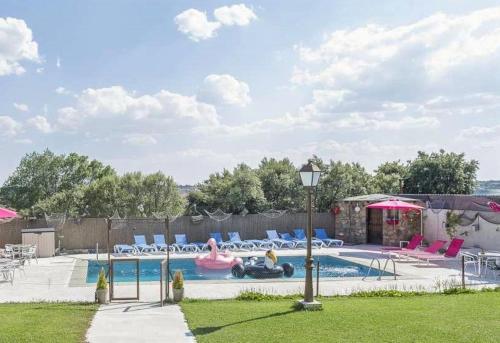 a swimming pool with chairs and a inflatable at yelmo LA CASA DE GALAPAGAR in Galapagar