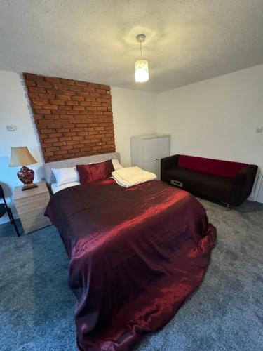 a bedroom with a large bed and a brick wall at Transformative housing lismore close in Nottingham