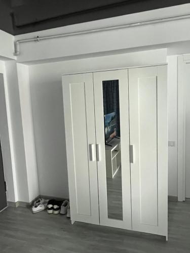 a room with white cabinets and shoes in a room at Studio in Năvodari