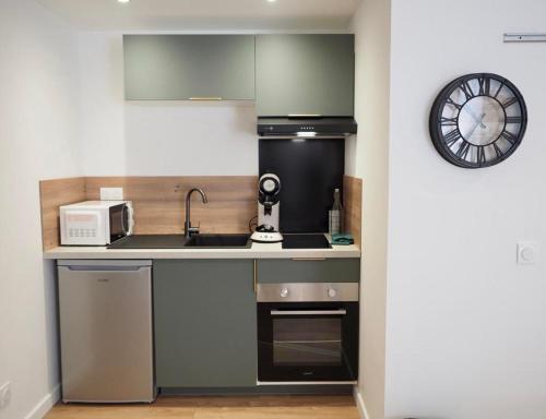 une petite cuisine avec un évier et un micro-ondes dans l'établissement Appartement cosy en plein centre historique de Besançon, à Besançon