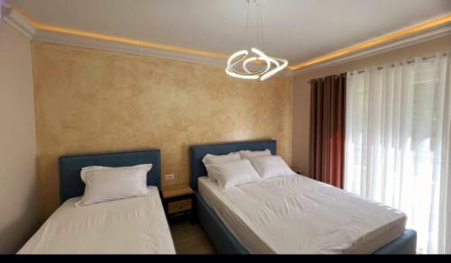 a bedroom with two beds and a window at Hotel DEMOLI in Pogradec