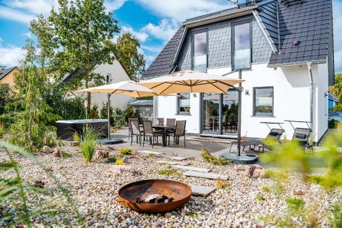 a backyard with a fire pit and two umbrellas at Auszeit Oase Heidi in Göhren-Lebbin