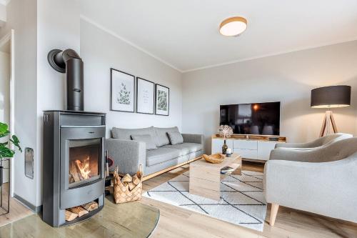 a living room with a fireplace and a couch at Auszeit Oase Heidi in Göhren-Lebbin