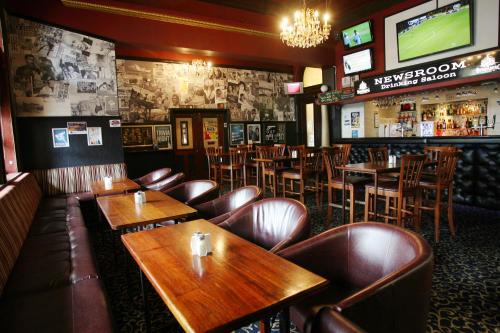 a restaurant with wooden tables and leather chairs and a bar at Criterion Hotel-Motel Rockhampton in Rockhampton