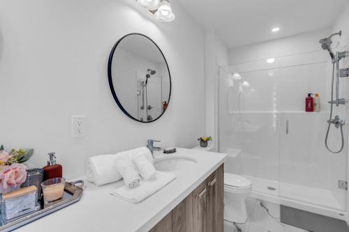 Un baño blanco con lavabo y espejo. en Luxury Newly Build 4BR House in Oakville, en Oakville