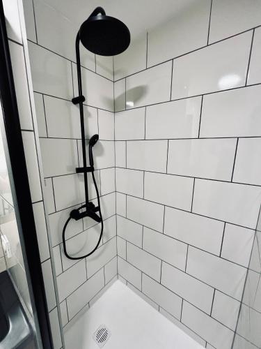 une douche avec des murs carrelés blancs et un luminaire noir dans l'établissement Appartement cosy en plein centre historique de Besançon, à Besançon