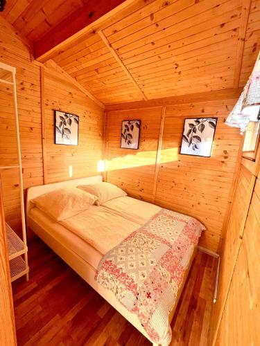 a small room with a bed in a cabin at Domki letniskowe Nadia in Grzybowo