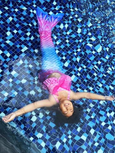 a girl in a pink dress laying in a swimming pool at 月出悠悠Moon Rise B&B in Hengchun