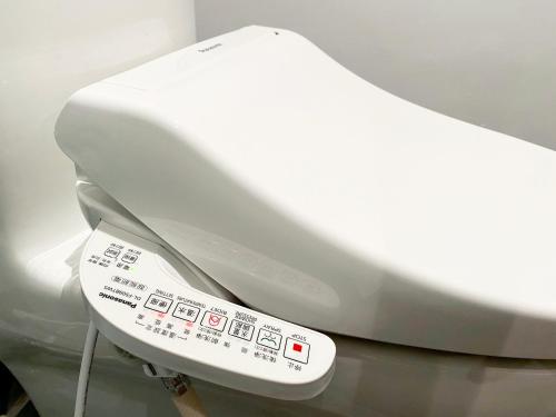 a close up of a white toilet with aperature at The Blue by Just Inn in Taipei