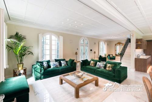 a living room with green couches and a table at Villa De Los Leones in heart of Sitges by Beach and Town with A/C and Games in Sitges