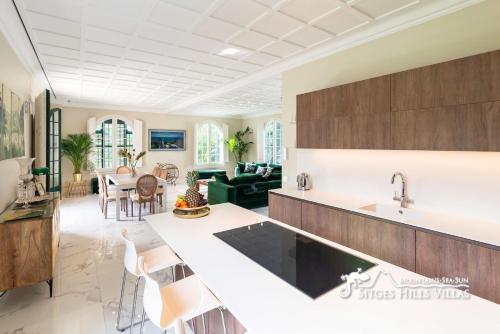 a kitchen and living room with a counter and chairs at Villa De Los Leones in heart of Sitges by Beach and Town with A/C and Games in Sitges