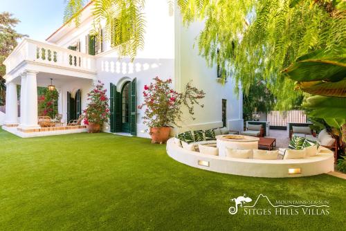 a house with a green lawn in the yard at Villa De Los Leones in heart of Sitges by Beach and Town with A/C and Games in Sitges