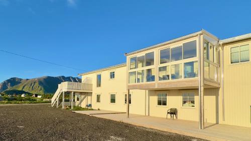 a building with a dog standing in front of it at Orcas View Vestresand Lofoten in Bøstad