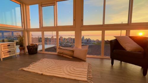 a living room with a couch and large windows at Orcas View Vestresand Lofoten in Bøstad