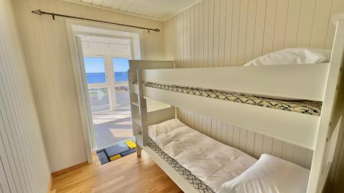 a bedroom with a bunk bed with a view of the ocean at Orcas View Vestresand Lofoten in Bøstad