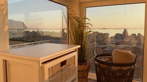 a room with a balcony with a large window at Orcas View Vestresand Lofoten in Bøstad