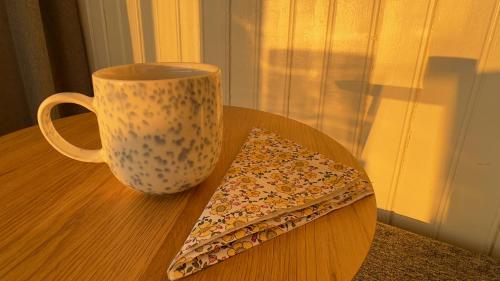 a cup and a napkin sitting on a table at Orcas View Vestresand Lofoten in Bøstad