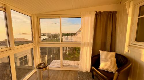 a living room with a chair and a large window at Orcas View Vestresand Lofoten in Bøstad