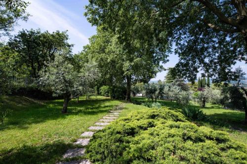 a path in a park with trees and grass at Appartamento Rupestre 2.0 in Manerba del Garda