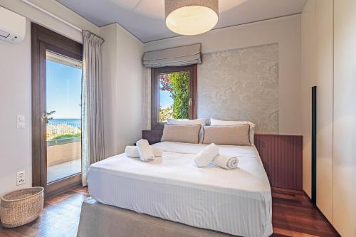 a bedroom with a large bed with a large window at Luxury Villa Aloe in Lygaria