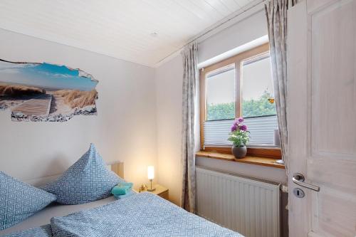 a bedroom with a bed with blue pillows and a window at Entenhaus in Hilgendorf