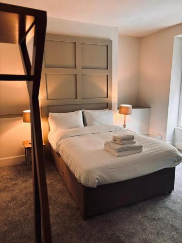 a bedroom with a large bed with two lamps on it at Harley's in Aberystwyth