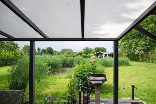 a screened in porch with a view of a garden at Entenhaus in Hilgendorf