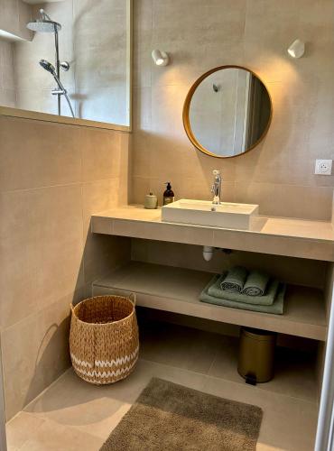 une salle de bain avec un lavabo et un miroir dans l'établissement Charmante villa rénovée avec piscine, à Montélimar