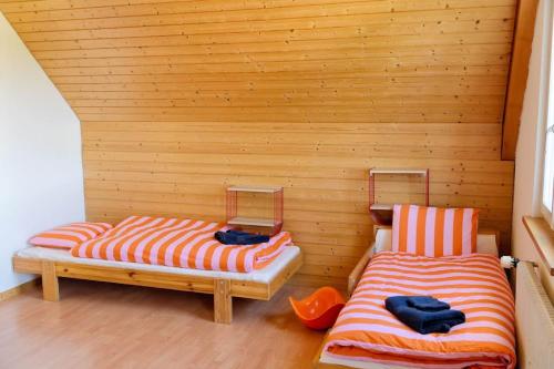two beds in a room with wooden walls at Dein Haus für den Zürich-Trip! in Adliswil
