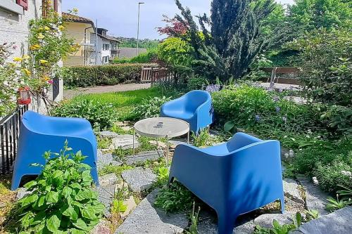 three blue chairs and a table in a garden at Dein Haus für den Zürich-Trip! in Adliswil