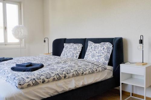 a bedroom with a blue bed with pillows on it at Dein Haus für den Zürich-Trip! in Adliswil