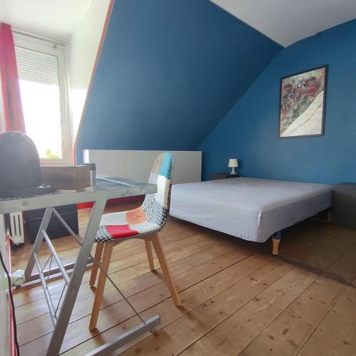 une chambre avec un lit, un bureau et une table dans l'établissement 7 min du circuit des 24 h du Mans et 10 min de la Gare - LA BERTINIERE, au Mans
