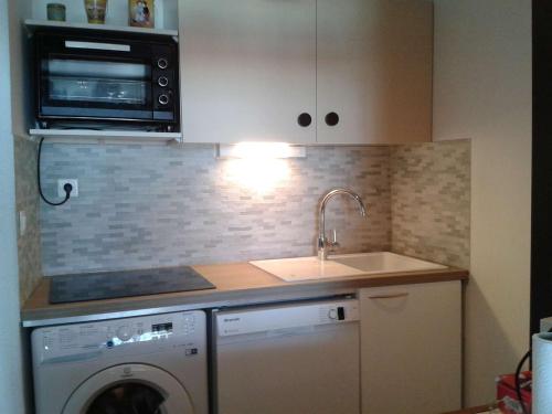 une cuisine avec un évier et une machine à laver dans l'établissement Appartement 3 pièces avec garage, La Grande Motte - FR-1-328-101, à La Grande Motte