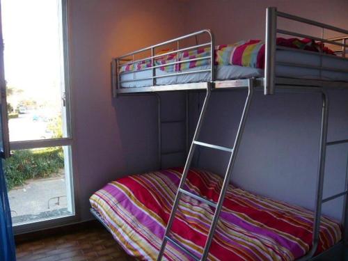 une chambre avec deux lits superposés et une fenêtre dans l'établissement Appartement 3 pièces avec garage, La Grande Motte - FR-1-328-101, à La Grande Motte