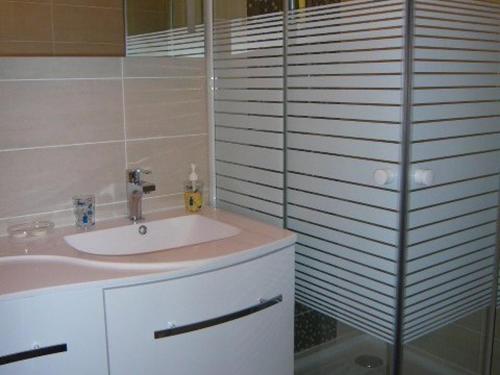 La salle de bains est pourvue d'un lavabo et d'une paroi en verre. dans l'établissement Appartement 3 pièces avec garage, La Grande Motte - FR-1-328-101, à La Grande Motte