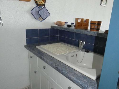 La salle de bains est pourvue d'un lavabo et d'un mur carrelé bleu. dans l'établissement Appartement 2 Pièces Cabine, Front de Mer, Parking, 4 Pers - FR-1-328-169, à La Grande Motte
