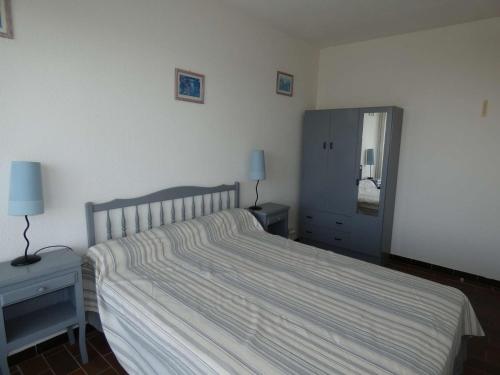 une chambre avec un lit, une commode et un miroir dans l'établissement 2 pièces cabine à La Grande Motte avec piscine et garage - FR-1-328-170, à La Grande Motte