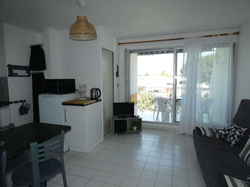 Il comprend une cuisine et un salon avec une table et une fenêtre. dans l'établissement 2 Pièces avec Piscine, Proche Plage et Commerces, Quartier Calme avec Parking Privé - FR-1-328-145, à La Grande Motte
