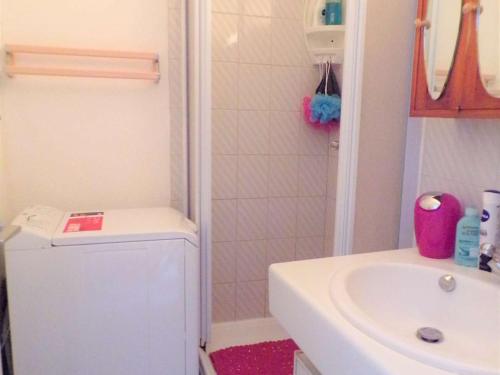 La petite salle de bains est pourvue d'un lavabo et d'un lave-linge. dans l'établissement 2 Pièces avec Piscine, Proche Plage et Commerces, Quartier Calme avec Parking Privé - FR-1-328-145, à La Grande Motte