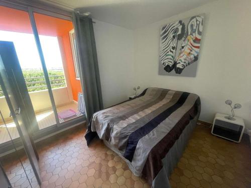 une chambre avec un lit et une grande fenêtre dans l'établissement Appartement 2 pièces cabine avec garage, à 300m de la plage, 6 personnes, La Grande Motte - FR-1-328-138, à La Grande Motte