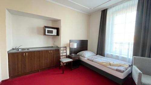 Habitación pequeña con cama y lavabo. en Hotel Černý Orel Žatec, en Žatec