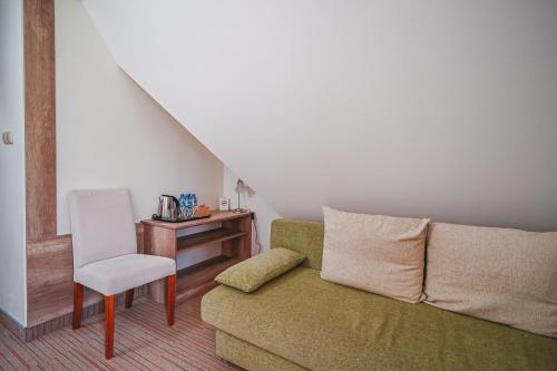 a living room with a couch and a chair at Hotel Eco Tatry Holiday& Spa in Kościelisko
