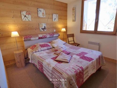 a bedroom with a bed with a wooden wall at Charmant appart. 70m², 2 chambres, mezzanine, balcon sud, garage, près commerces, navettes - FR-1-458-110 in Le Grand-Bornand