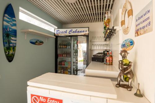 a fast food restaurant with a counter and a refrigerator at Beach Cabanas in Jeffreys Bay