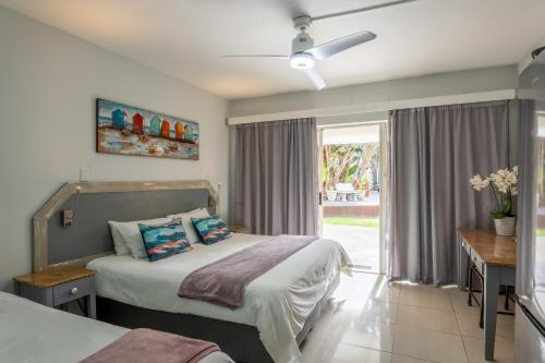 a bedroom with two beds and a window at Beach Cabanas in Jeffreys Bay