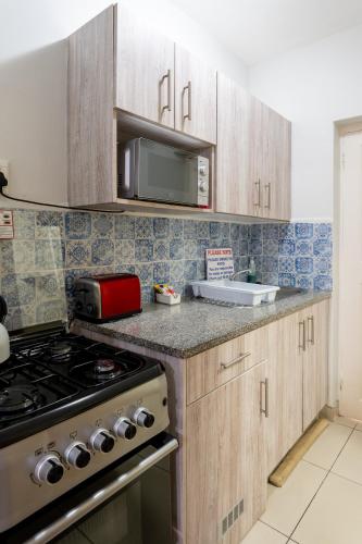 a kitchen with wooden cabinets and a stove top oven at Beach Cabanas in Jeffreys Bay
