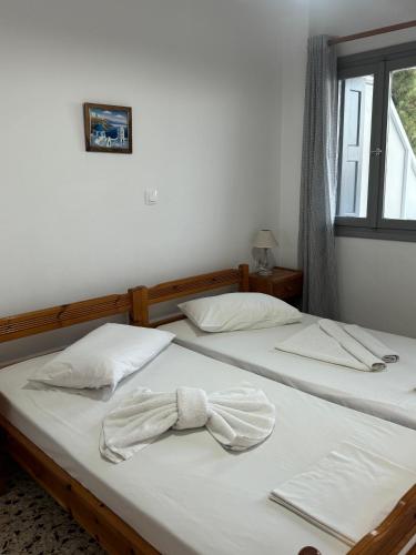 two beds in a room with a bow tie on them at Akti Rooms And Studios in Livadion
